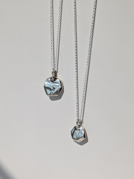 Two silver necklaces with pendant stones on a light gray background, giants causeway irish jewellery